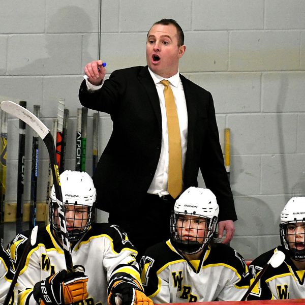 Coach diagramming a drill with a young player leaning in