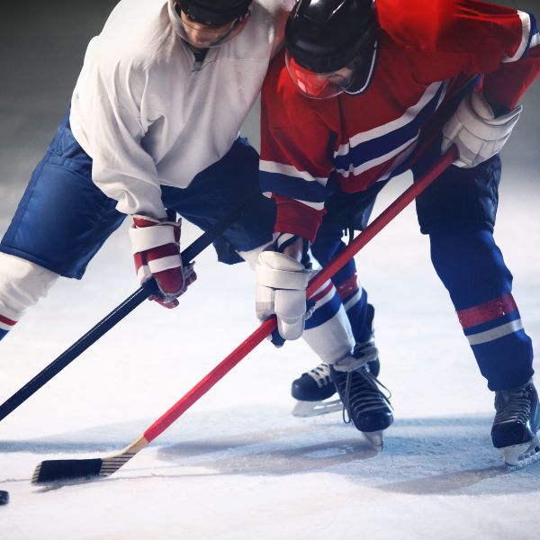 Two players battling along the boards for the puck